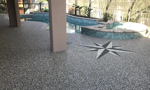 Residential epoxy stone pool deck and entryway with decorative compass design and seamless non-slip finish